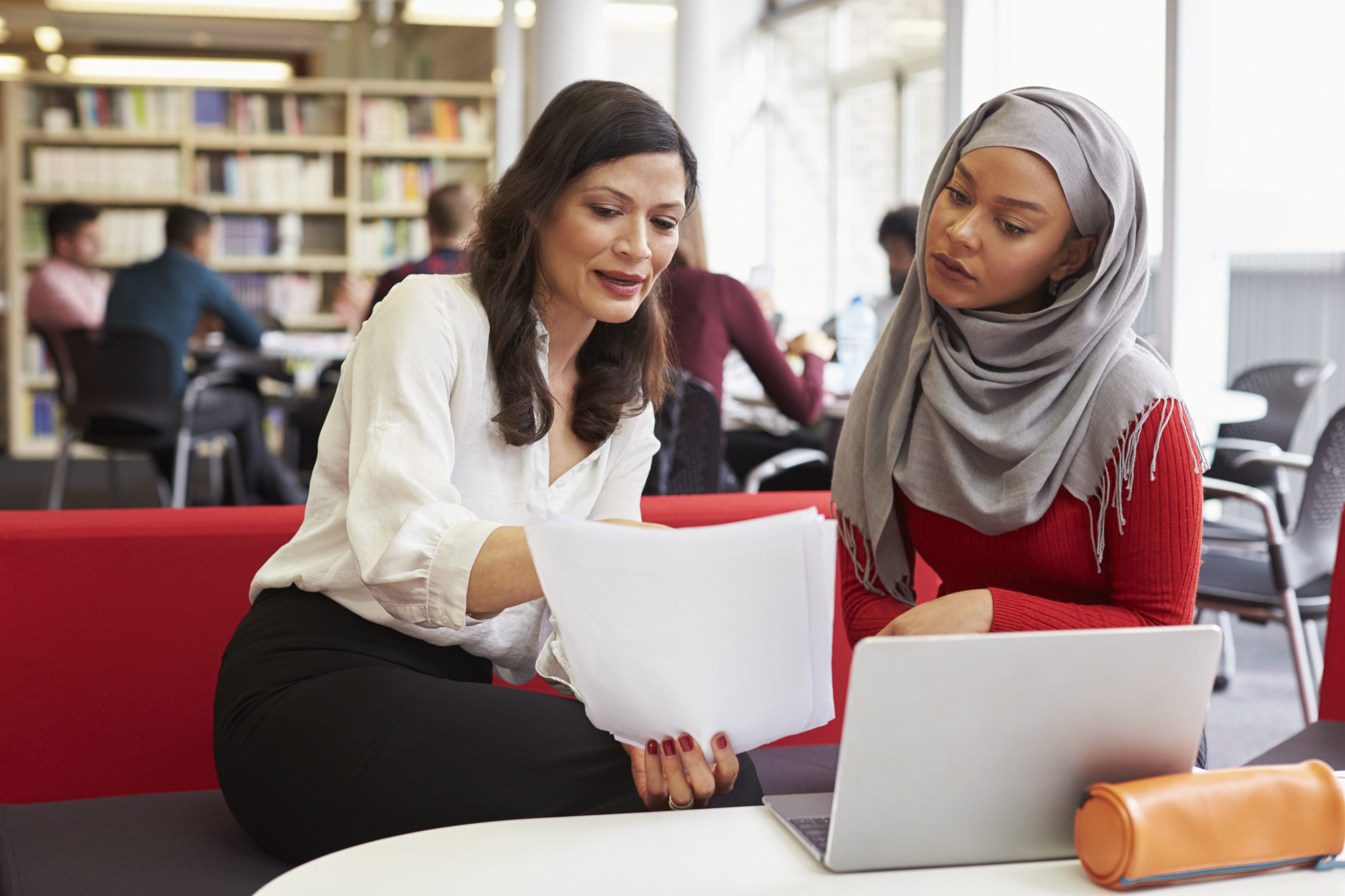 Two women looking at papers together